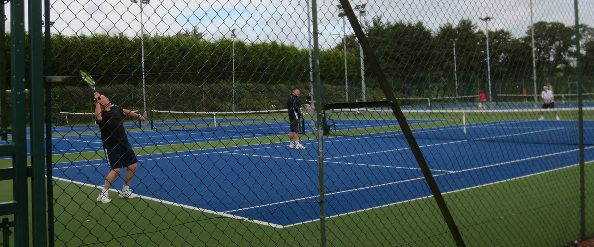 Members playing on the outdoor courts in front of the clubhouse